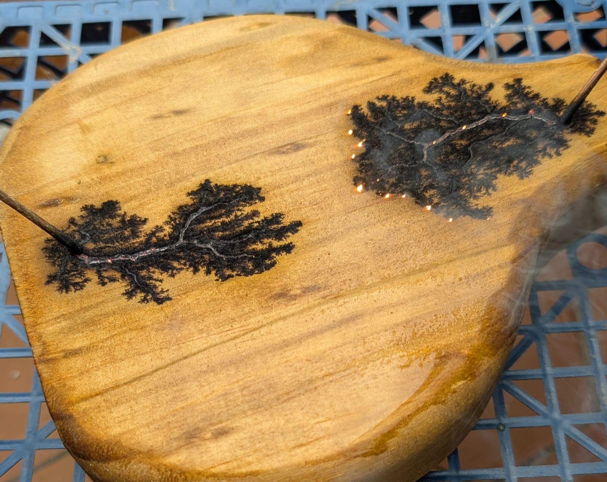 Pyrographie en cours sur planche ronde – motifs forêt brûlés au feu